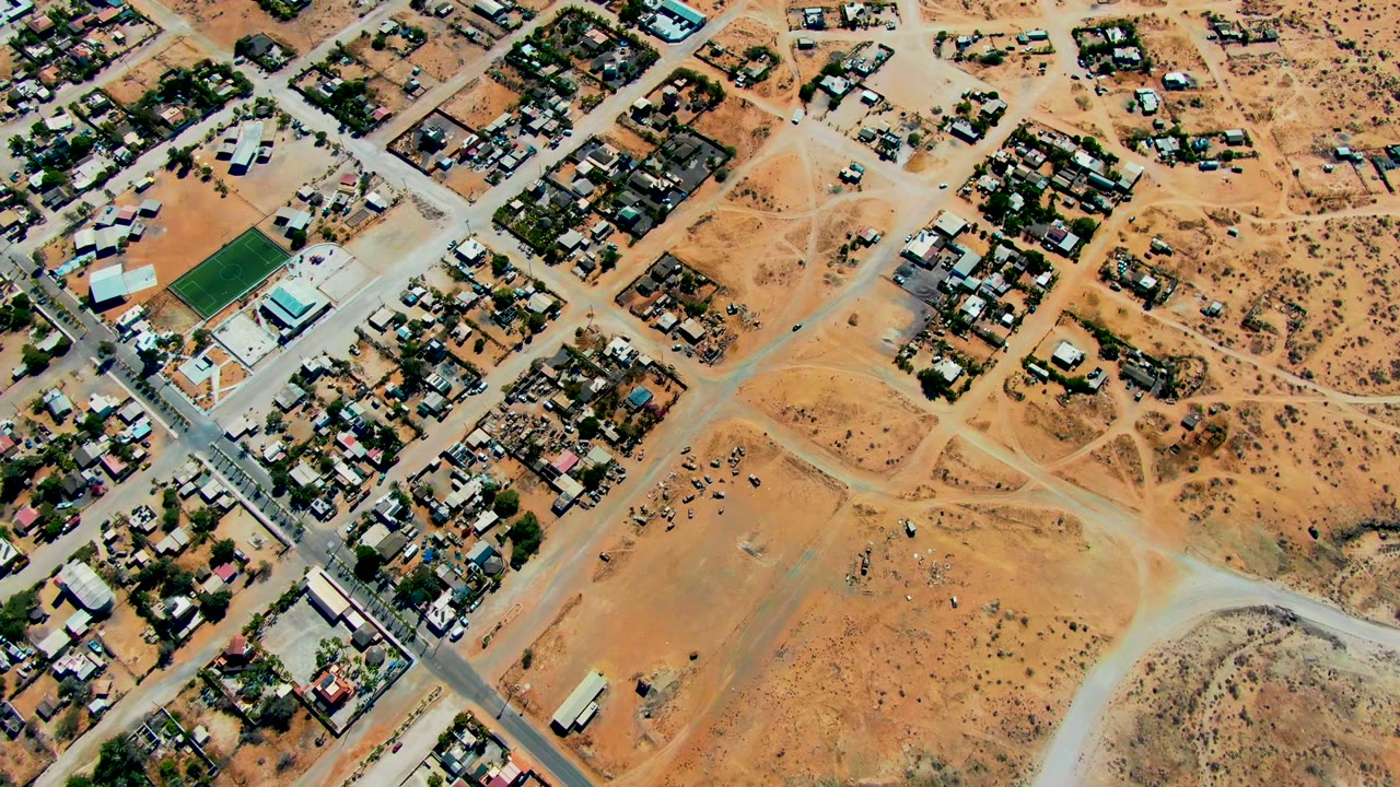 Aerial neighborhood grid beside open sandy lots