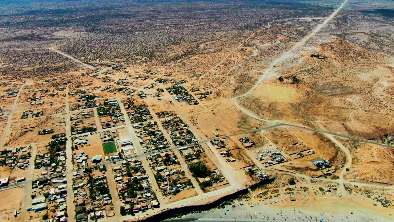 Aerial view of gridded town roads and sandy hills