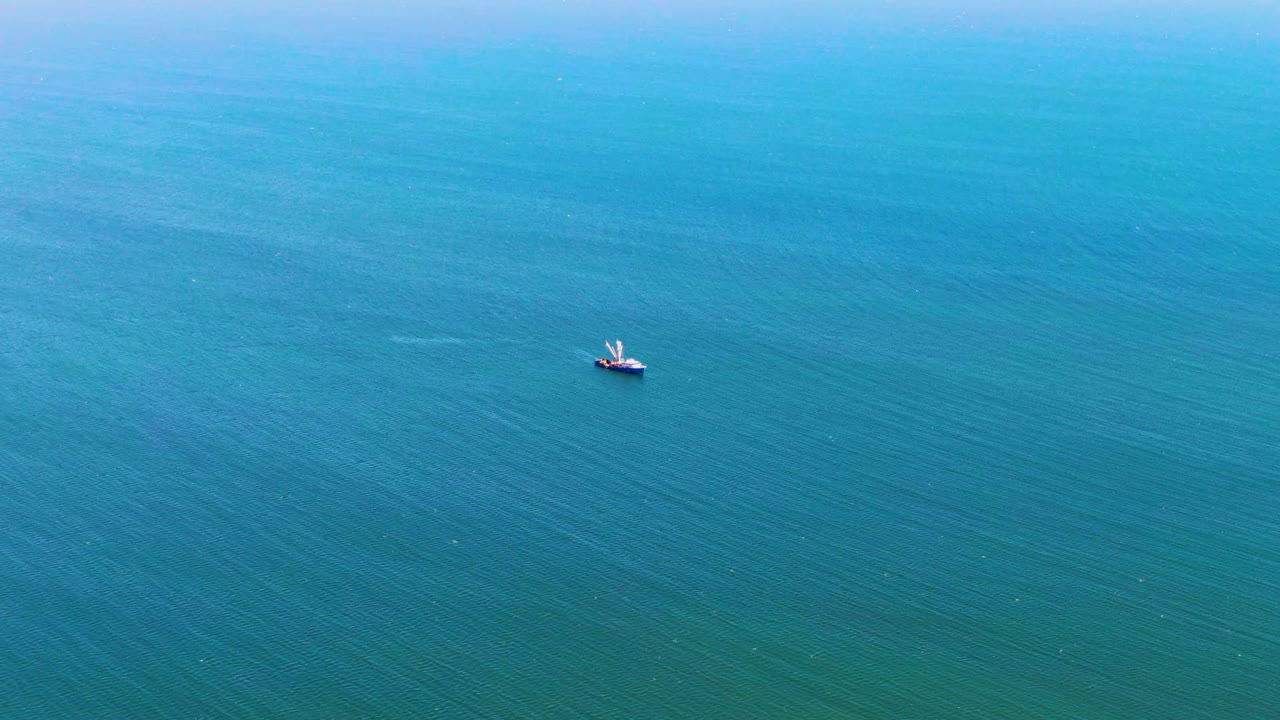 Small boat on open blue-green sea