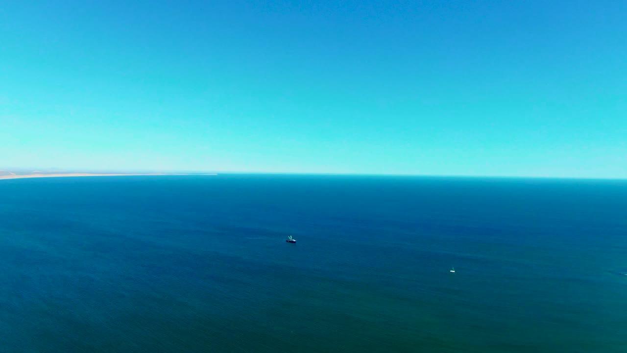 Aerial ocean horizon with two small boats on calm water