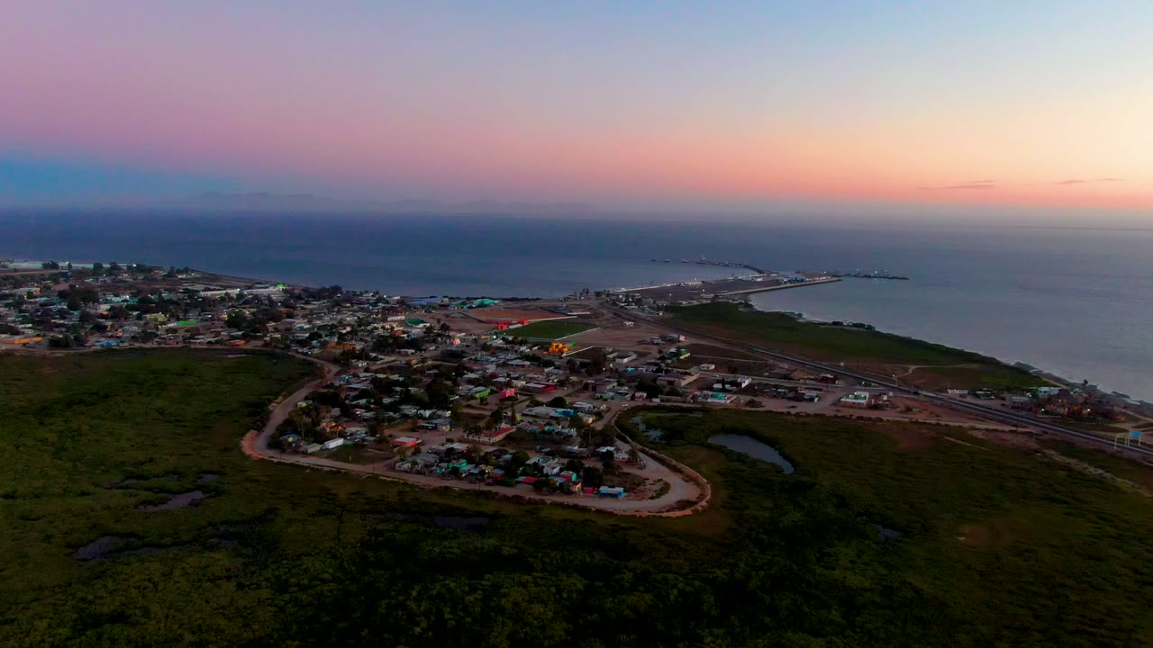 Coastal settlement and roads seen from above at dusk.