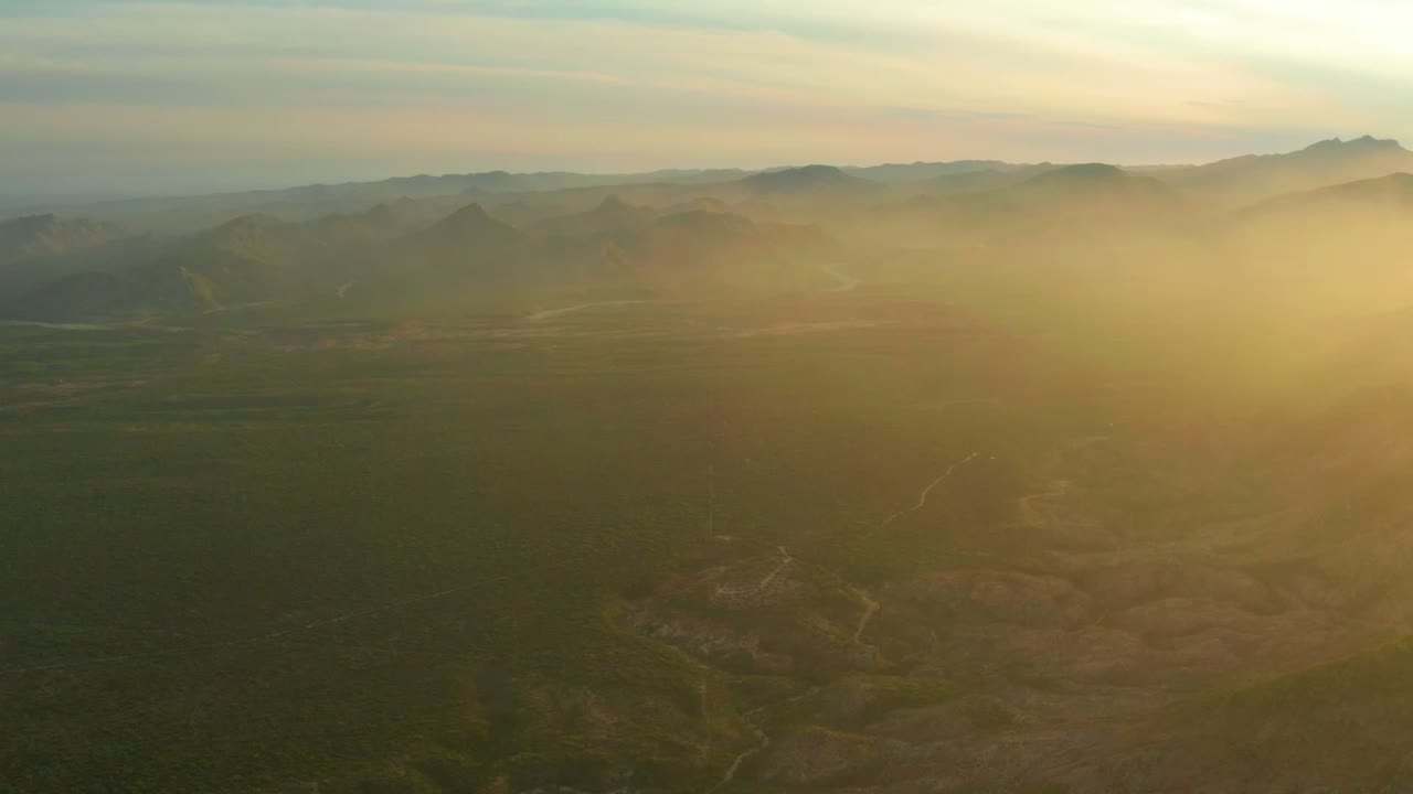 Wide valley landscape with distant mountains and haze.