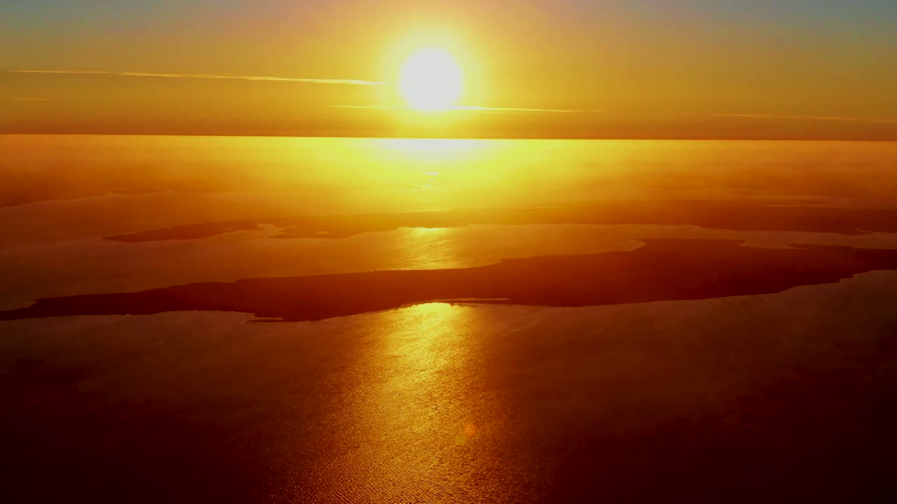 At 0:00 in San Carlos, Baja California Sur, the sun sits above the horizon with a bright gold reflection across dark water and no visible people.