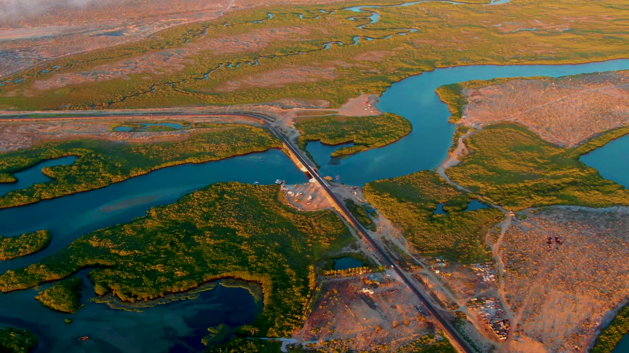 Overhead runway and river junction bordered by marsh vegetation.
