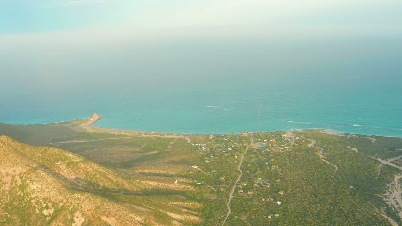 Coastal hills and ocean seen from above with roads through vegetation