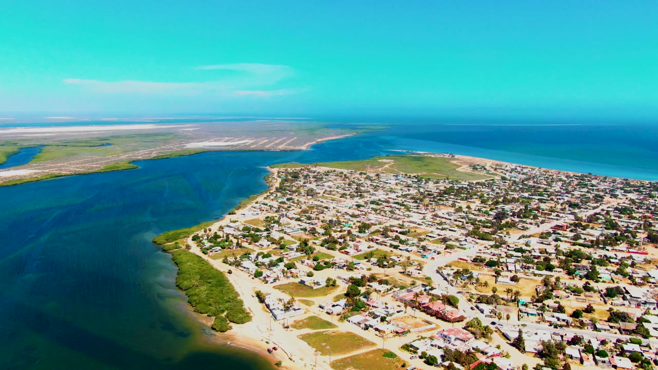 Coastal town and inlet under brighter turquoise sky