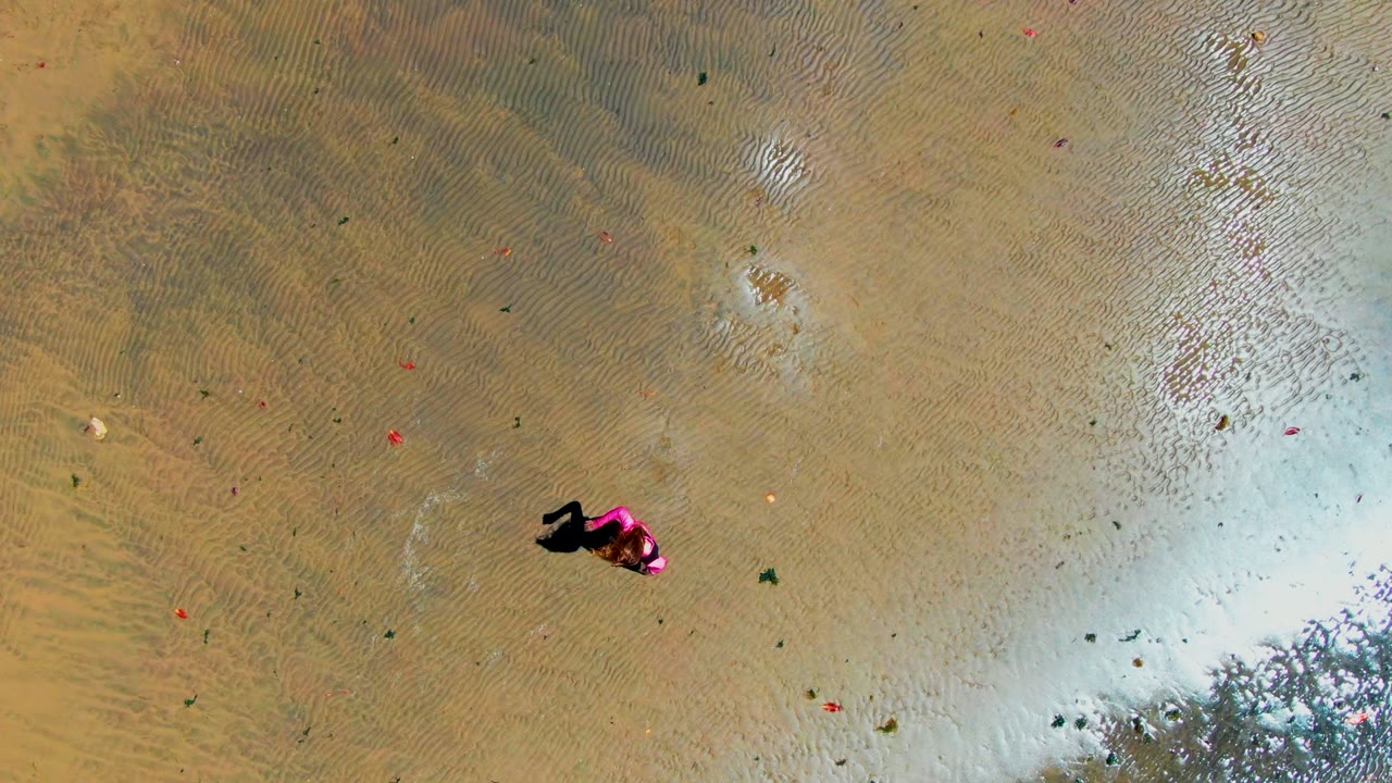 Person and shadow over rippled shallow water