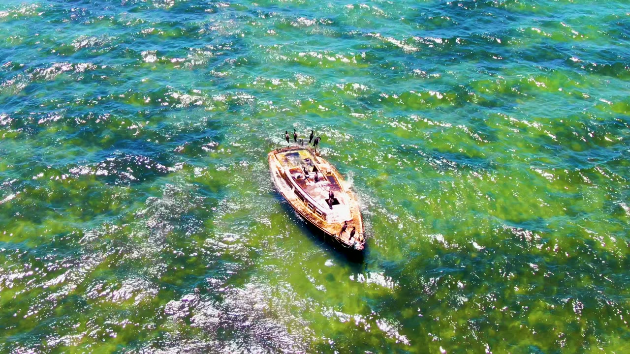 Boat with people surrounded by rippled turquoise water