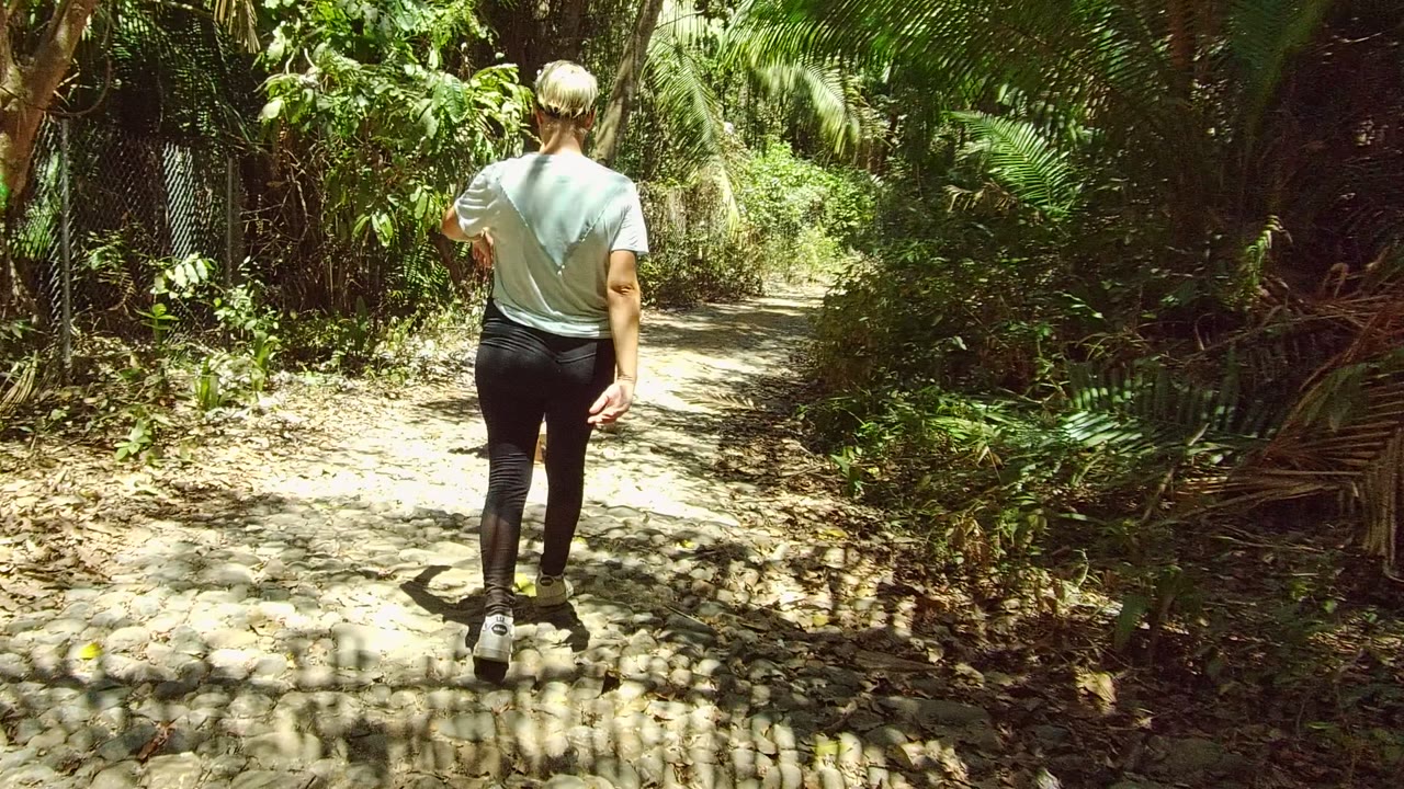 Adult continuing along a rough dirt path through trees.