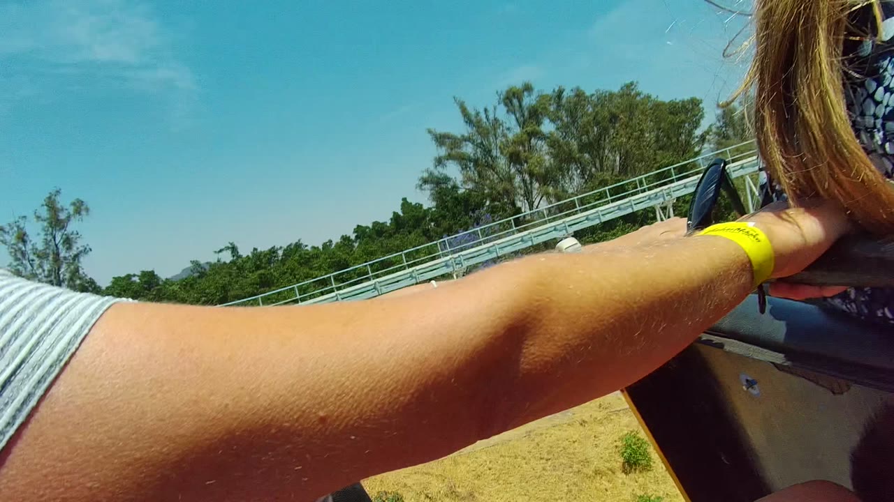 Close side view of a blonde woman smiling on a roller coaster.