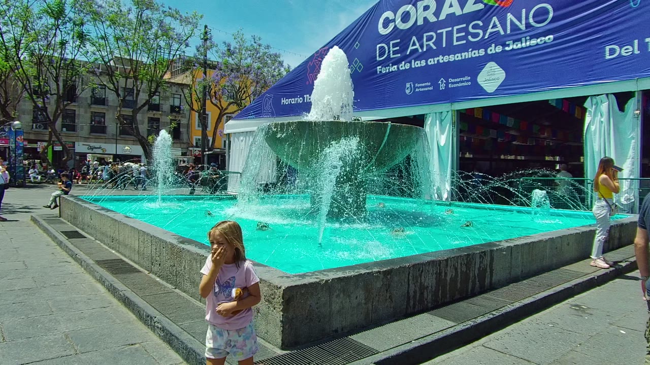 Blue fountain spraying water in front of artisan fair tent