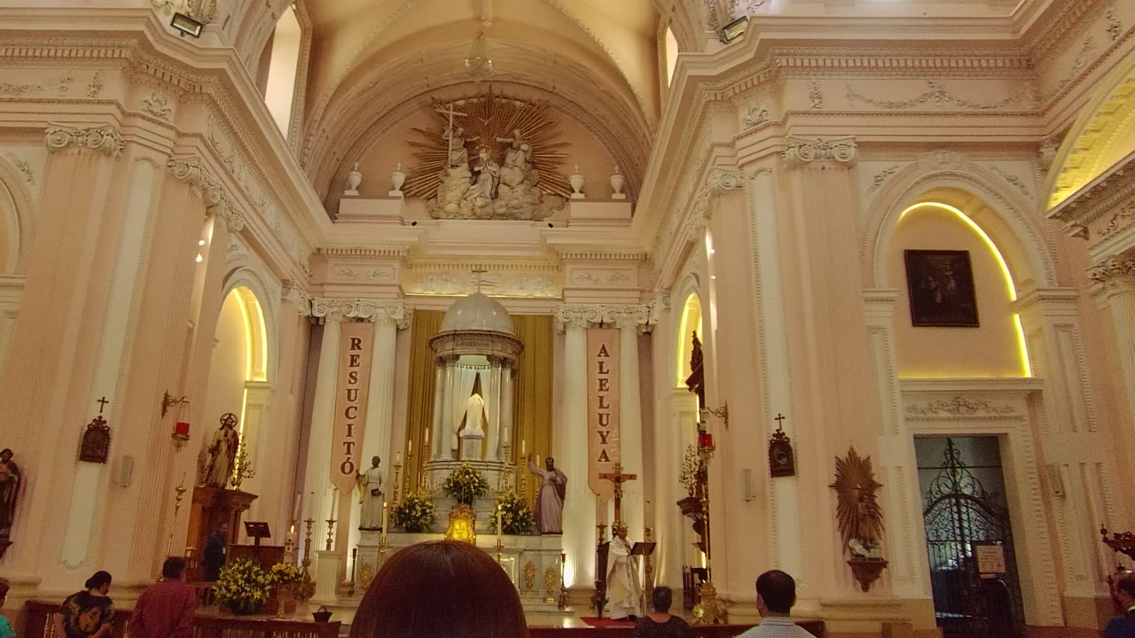 A later view of the Guadalajara church shows the altar below a high arch, with banners reading vertically at each side and a visitor's head low in the foreground.