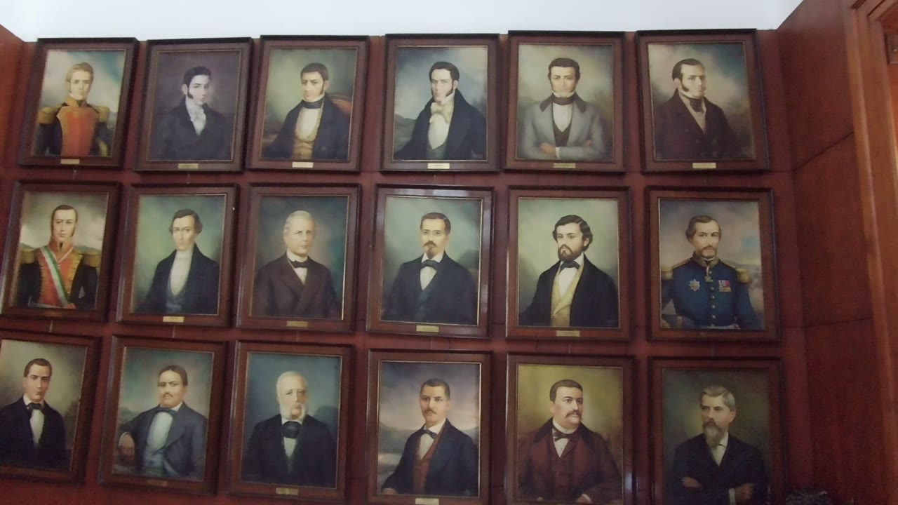 A Guadalajara interior wall filled with rows of framed male portraits in dark wood, including men in formal coats, ties, and mustaches.