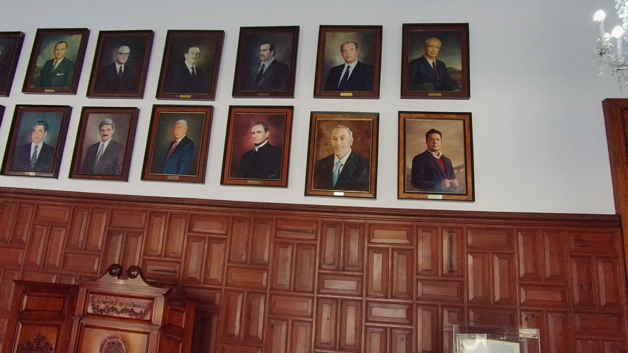 Framed portraits and wood paneling with lectern below