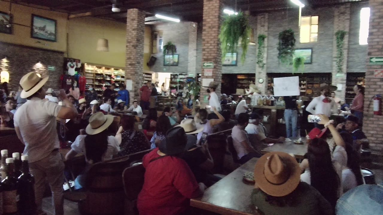 Workshop audience facing a speaker beside a whiteboard in a rustic indoor room.