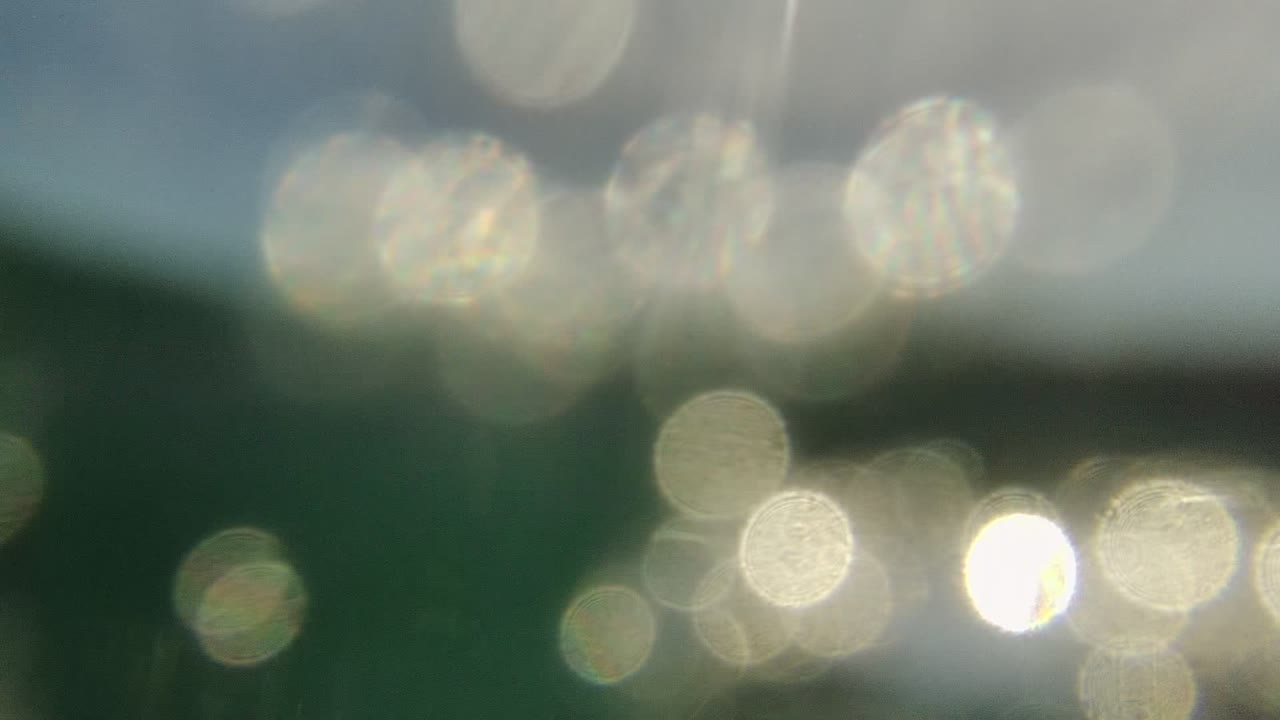 Blurred underwater surface with bright circular reflection bokeh