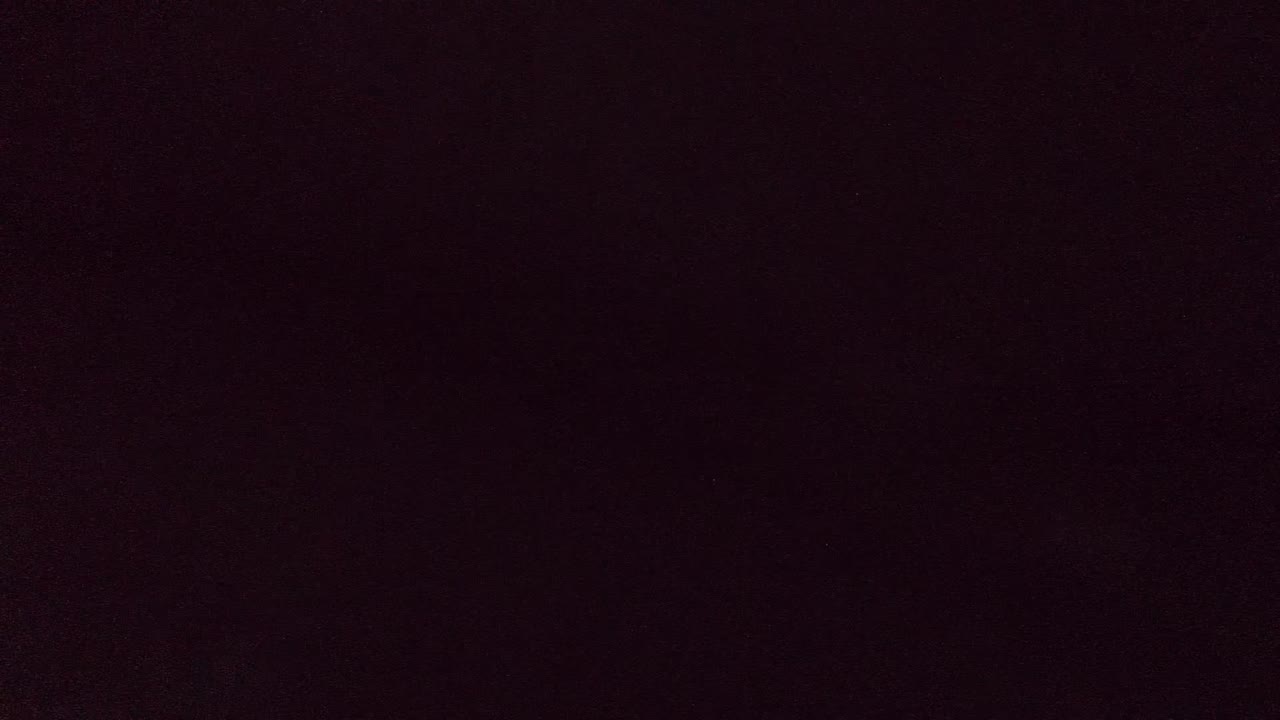 Nearly black opening frame from the Cabo Pulmo underwater clip, with only a faint red-brown color cast and no identifiable subject visible.