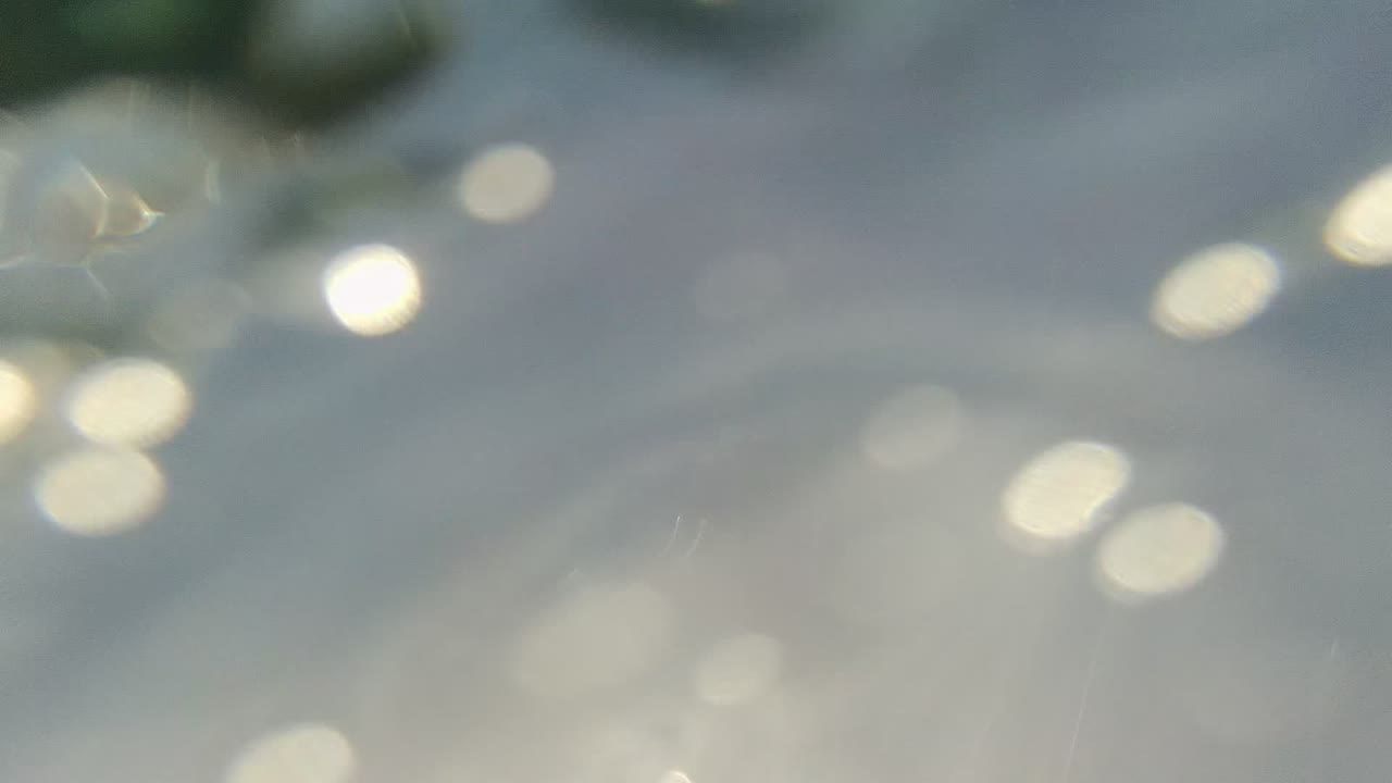 Soft water reflections and bright bokeh fill the first frame from Cabo Pulmo, with no visible people.