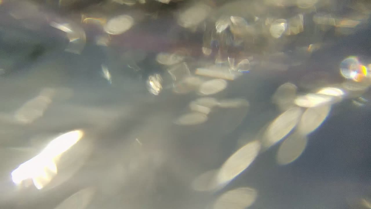 Soft white reflections and scattered bubbles blur across the underwater surface in Cabo Pulmo, with no visible people.