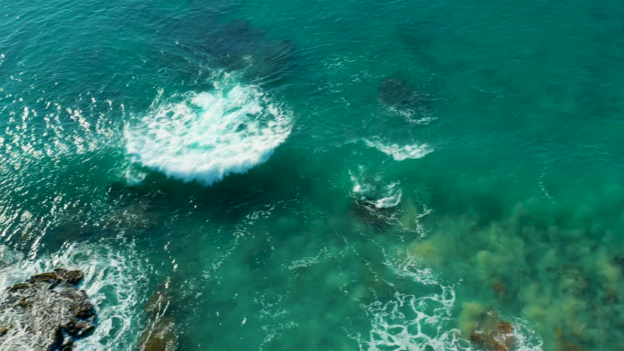 White foam spreading across clear turquoise water