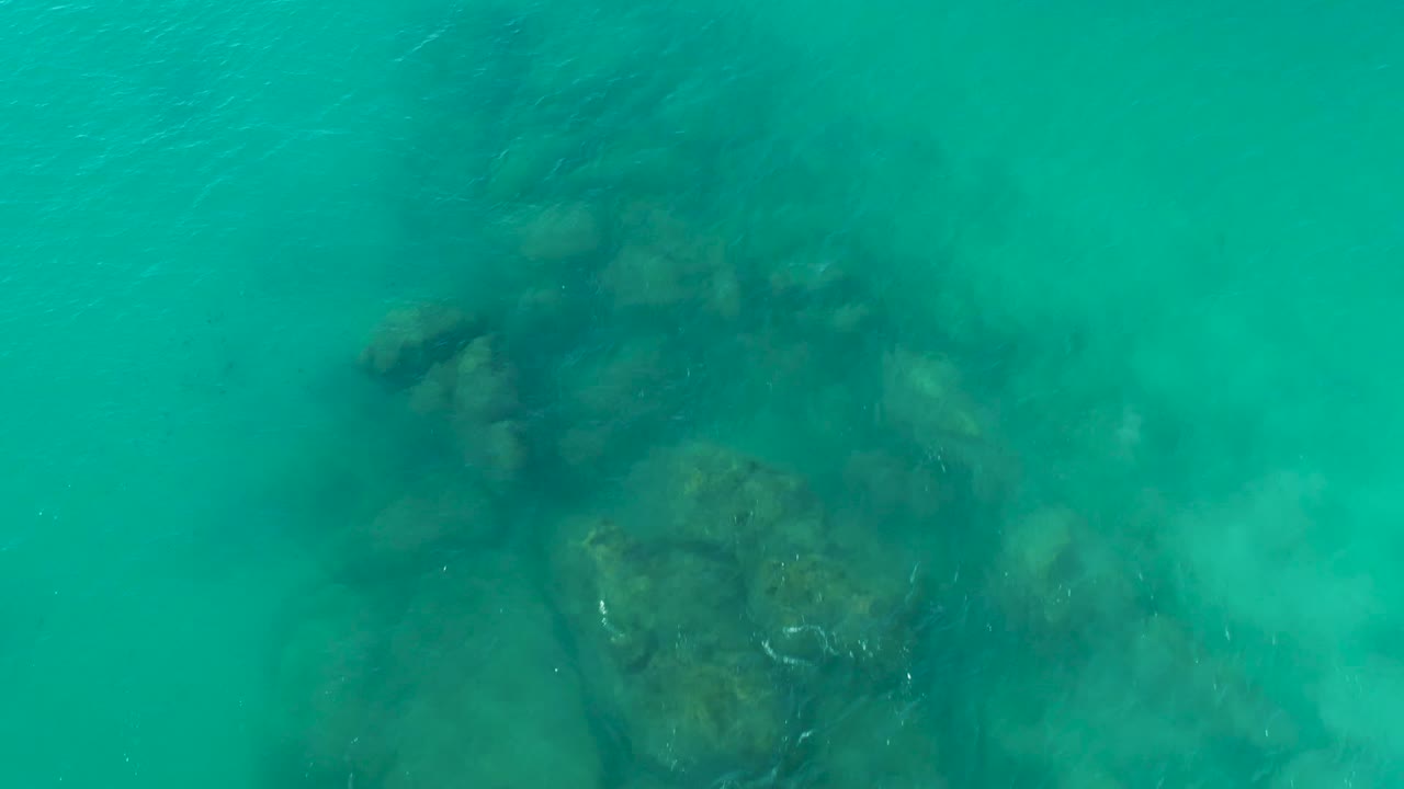 Submerged rock formation beneath rippled water