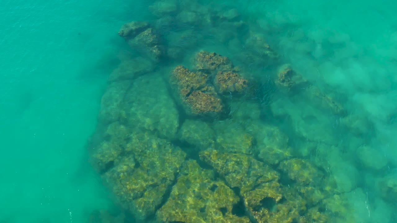 Rocky seabed seen through clear turquoise water