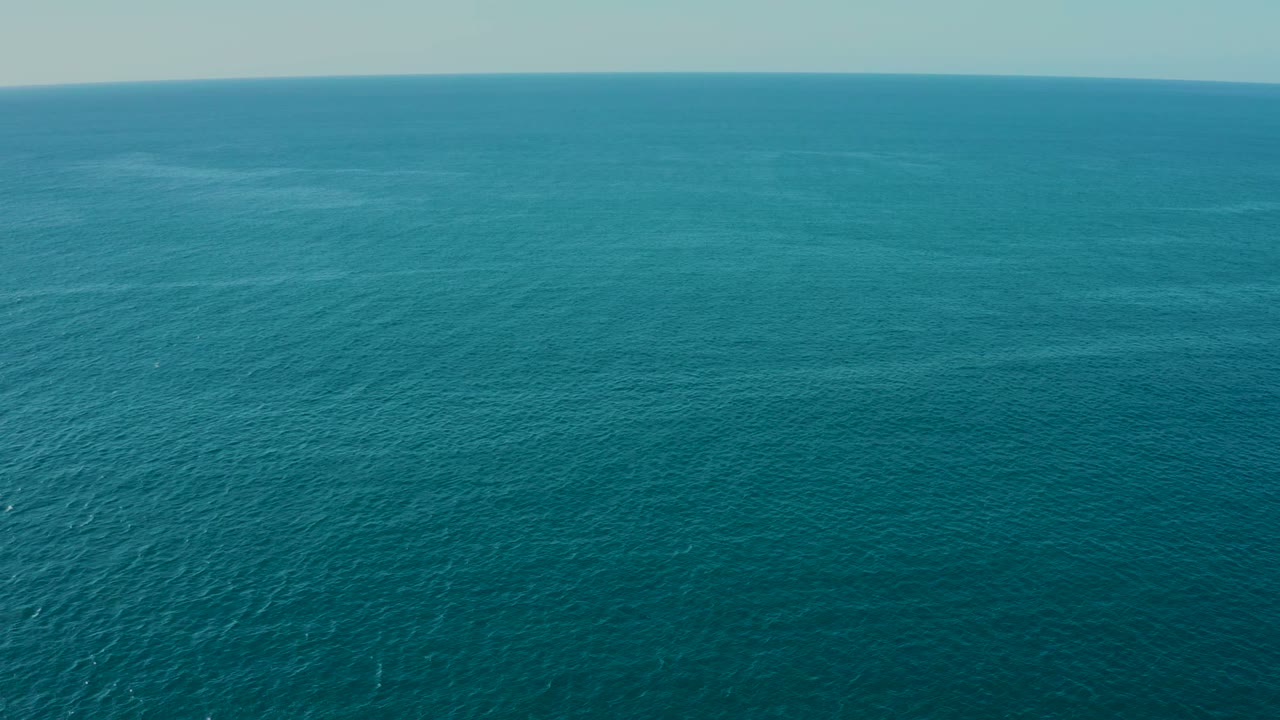Wide aerial view of blue-green ocean water near La Fortuna, Baja California Sur, with a pale horizon and no visible people.