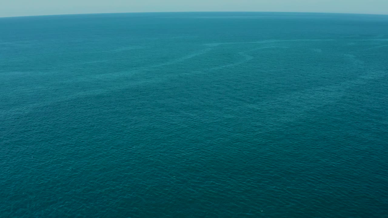 Open ocean surface with faint tonal bands in the water.