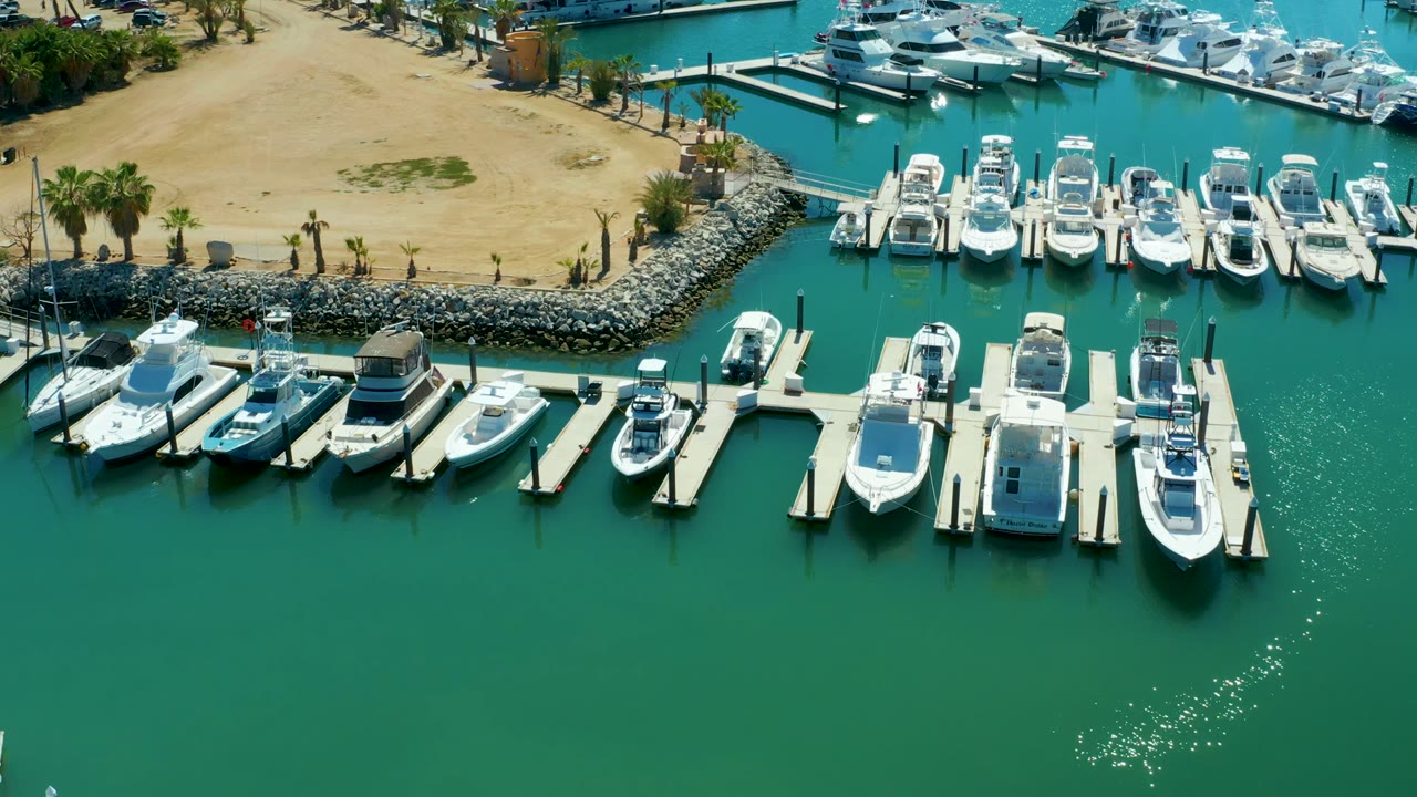 Docked boats and floating piers seen from above with open green water below.