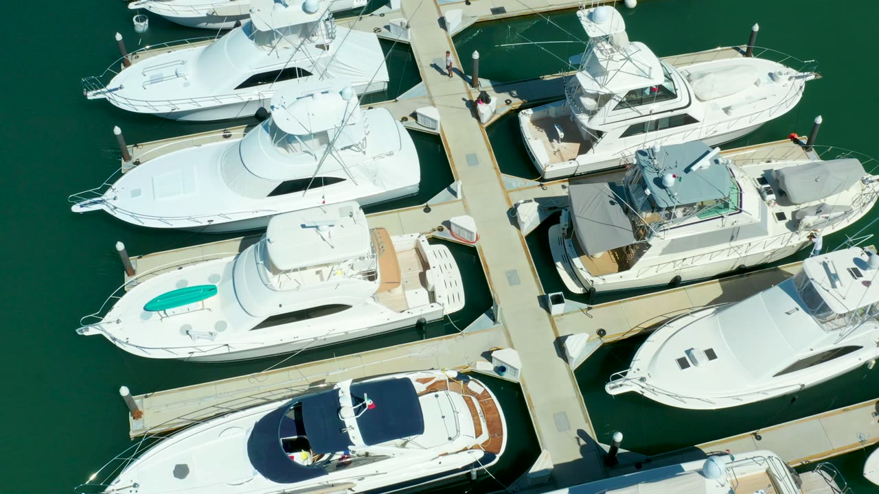 Aerial marina view with white boats lining both sides of a dock.