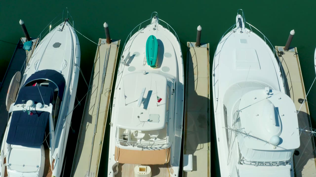 Top-down view of three docked boats with a turquoise item on one deck.