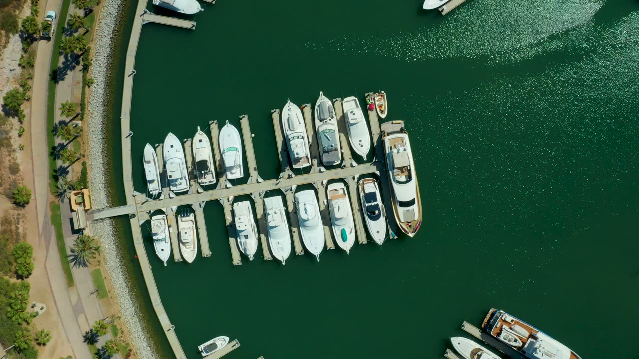 Aerial view of marina slips with boats and rippled green water.