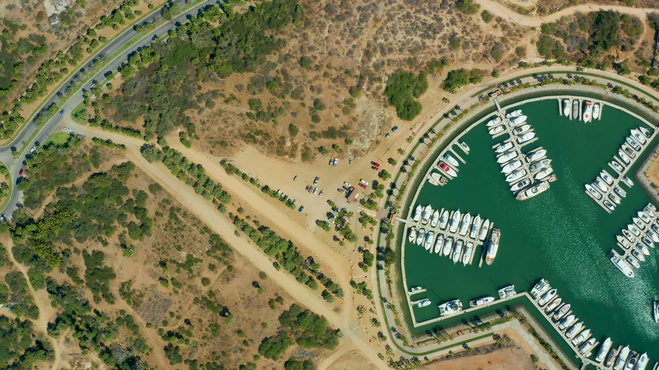 Third frame shows Puerto Los Cabos marina from directly above, with docked white boats in green water, small cars near the sandy parking area, scrub-covered land, and no visible people.