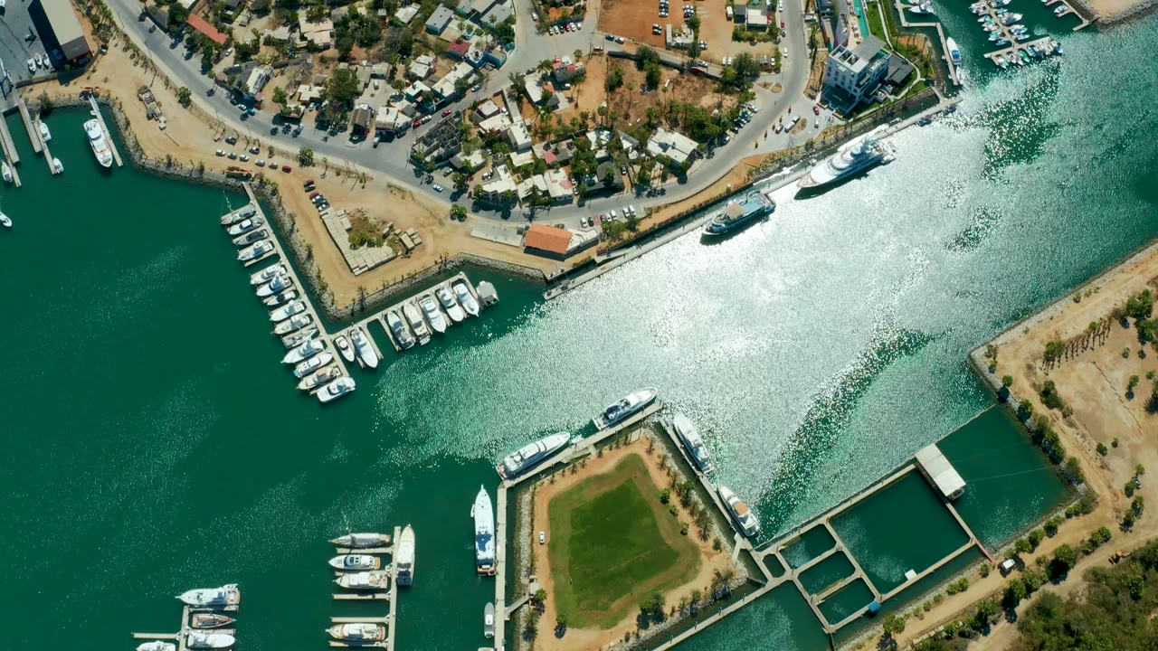 Drone view of marina water, docks, yachts, and shoreline roads.