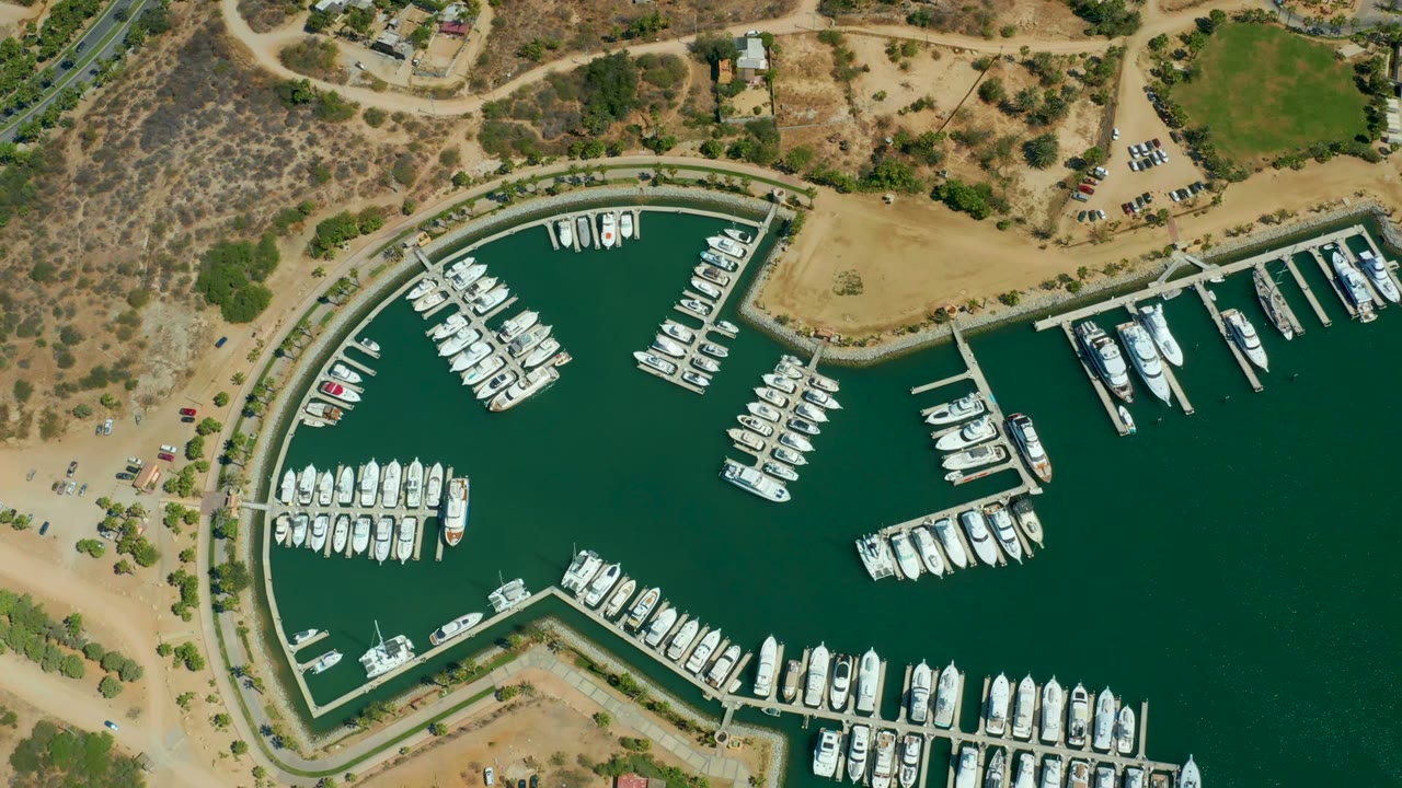 Aerial view of docks and boats inside a green-water marina.