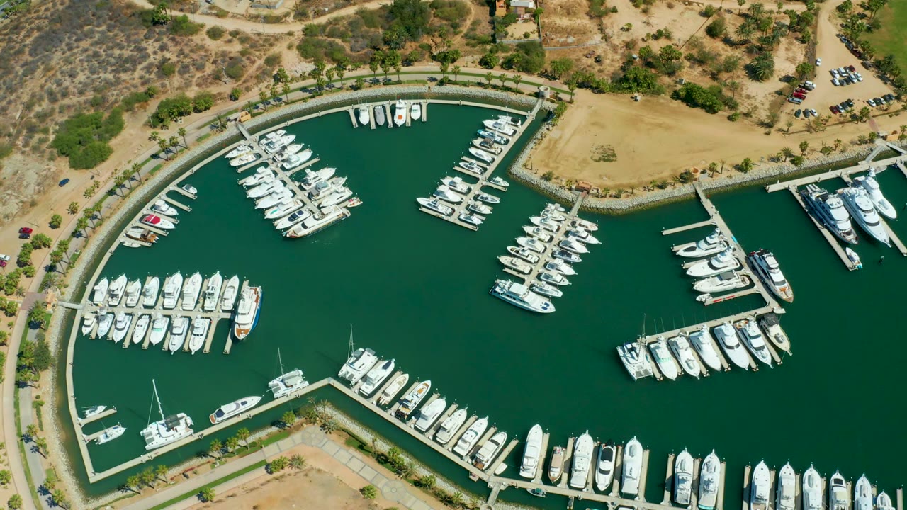 Aerial view of docked boats around a curved marina basin.