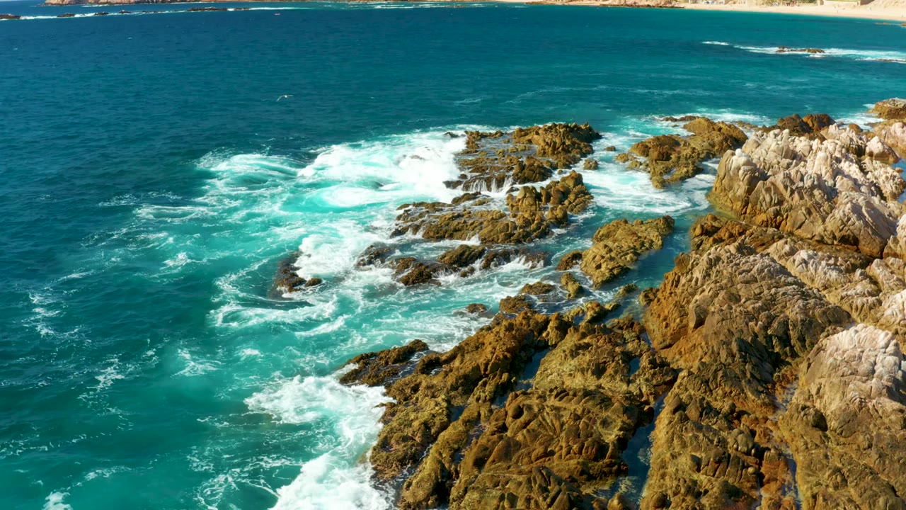 White surf swirling through rocky inlets beside the ocean.