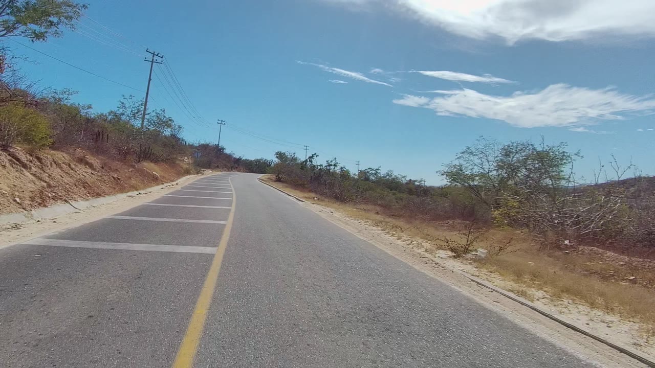 Rural road with utility poles and dry hillside brush