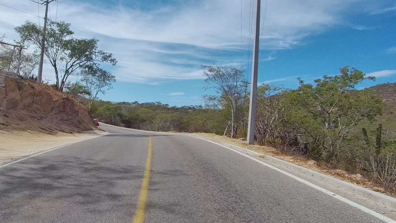 Road bend with utility pole and dry hillside