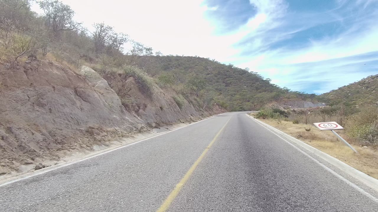 Roadside slope and empty asphalt road in arid terrain