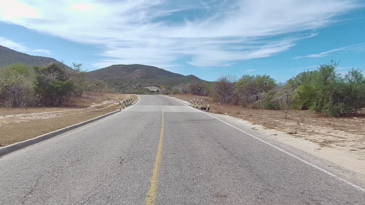 Road approaching a small bridge in arid terrain
