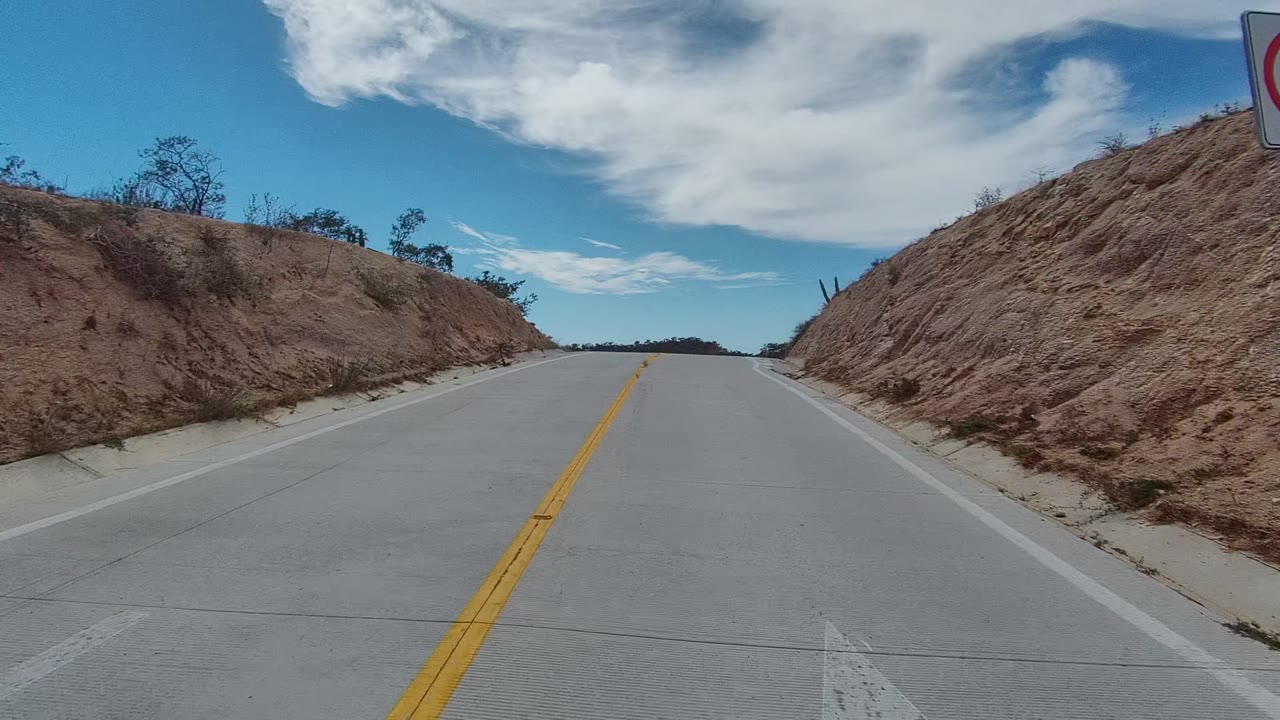Forward road view with dirt embankment close on the right