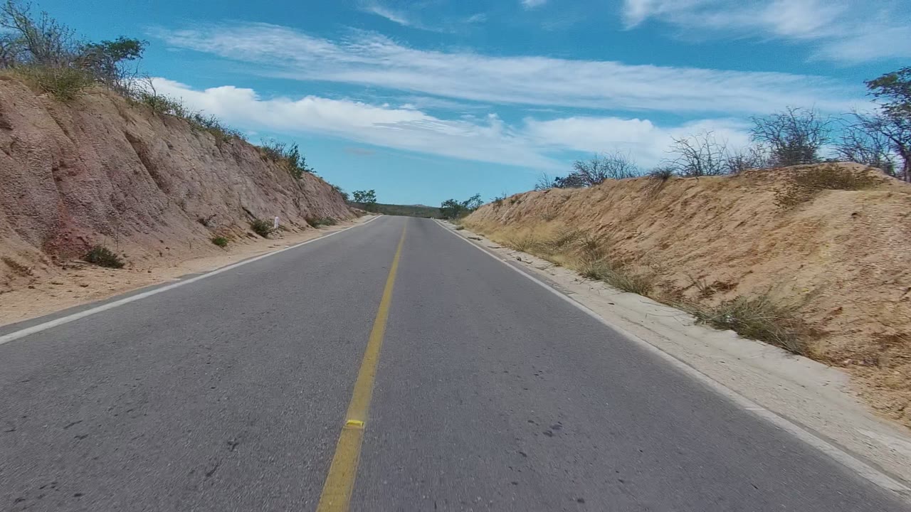 Road centered between sandy roadside banks