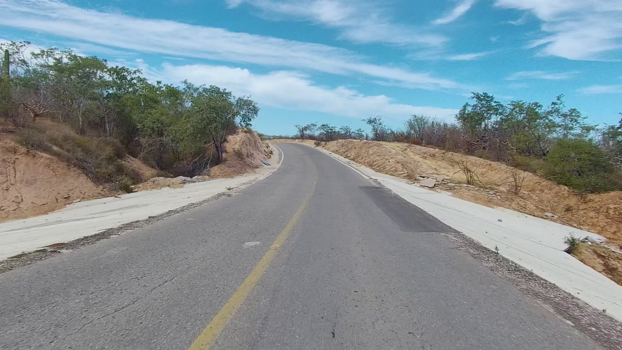 Curving paved road through dry hills and brush