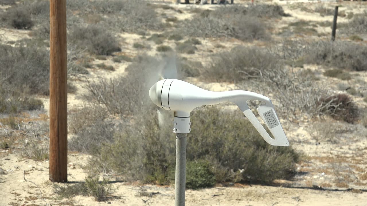White wind vane blurred by motion in dry scrubland