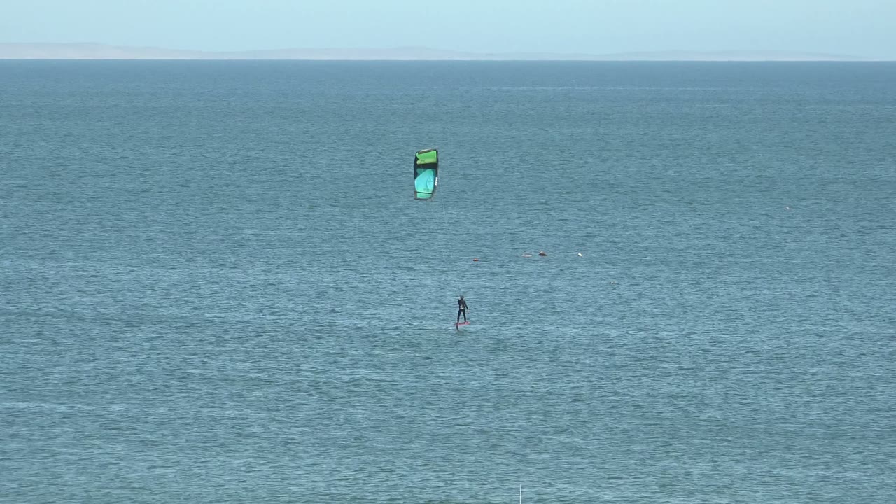 At two seconds, the kite appears near the upper right portion of the wide San Juanico ocean view, with the rider still small and no recognizable facial or body detail visible.