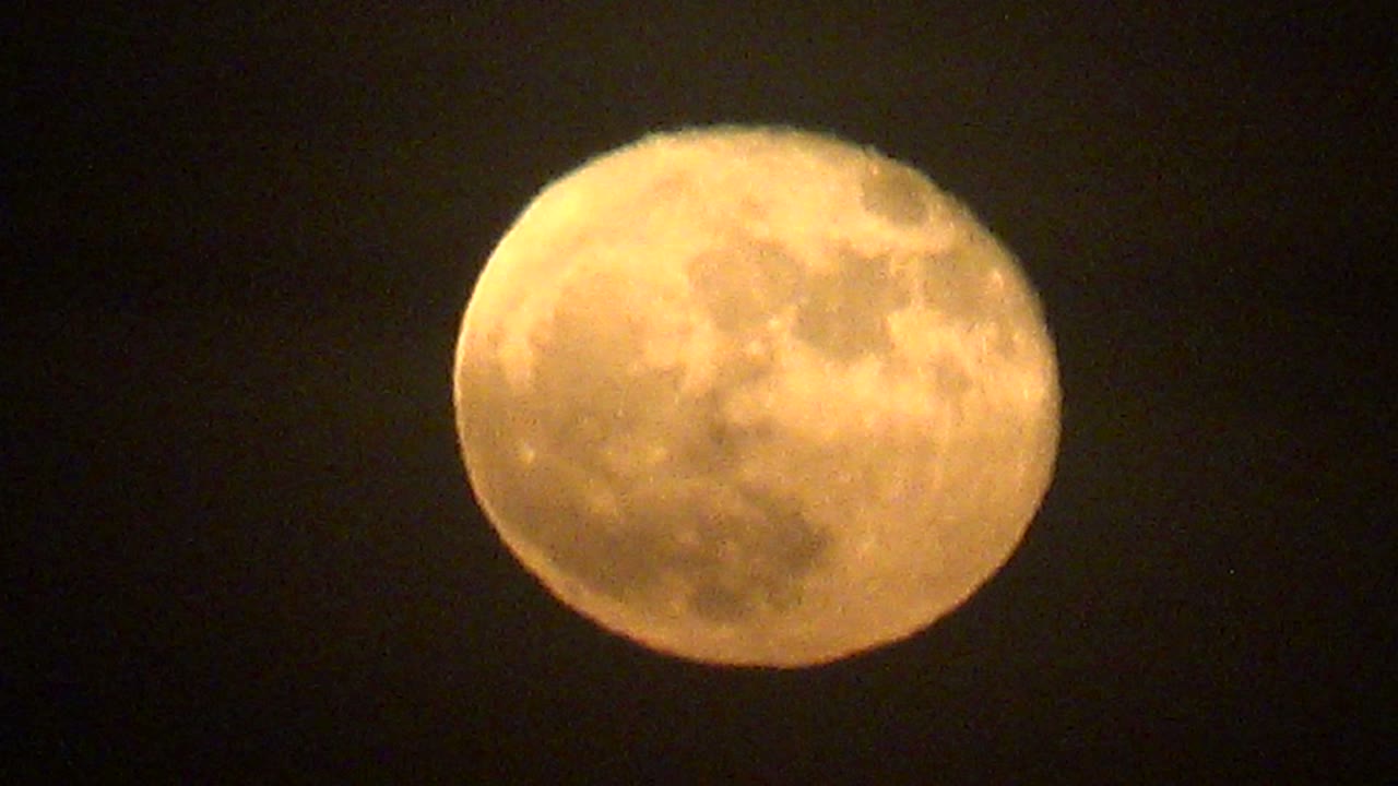 A warm full moon sits left of center against the dark La Bocana night sky, with faint cloud haze near its upper edge and no visible people.