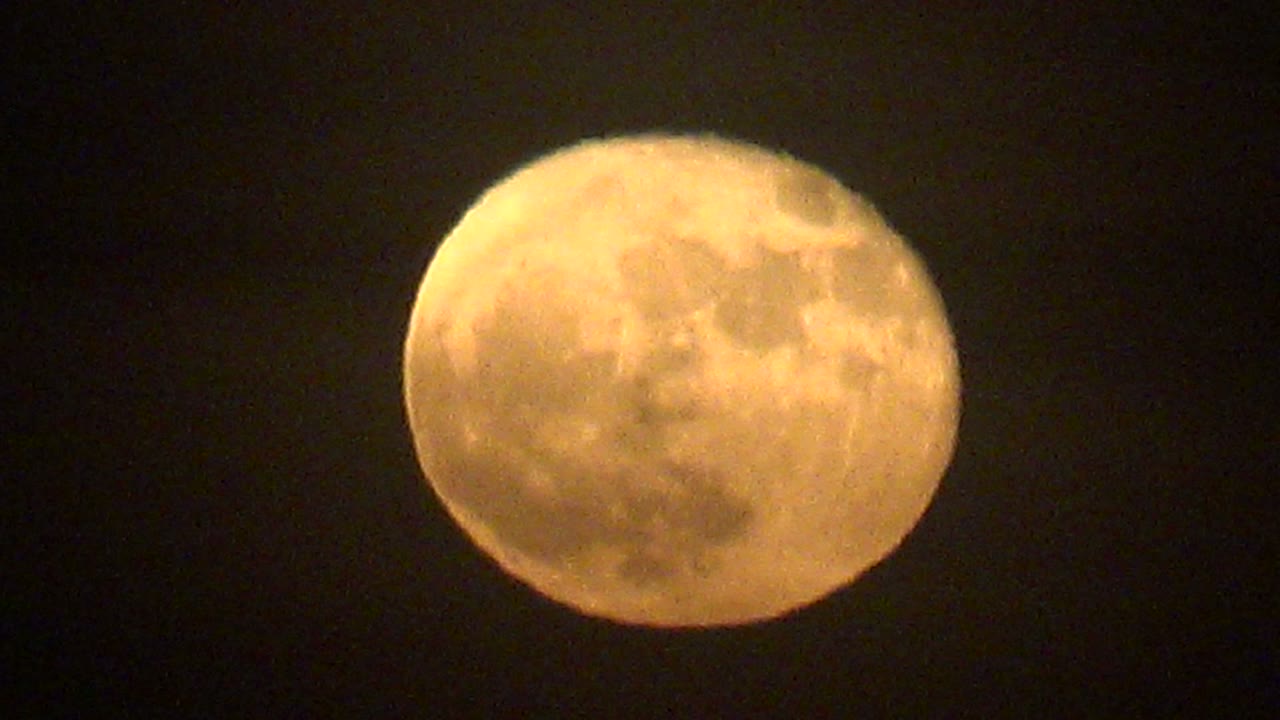 Warm orange full moon centered against a dark night sky in La Bocana, Baja California Sur, Mexico, with no visible people.