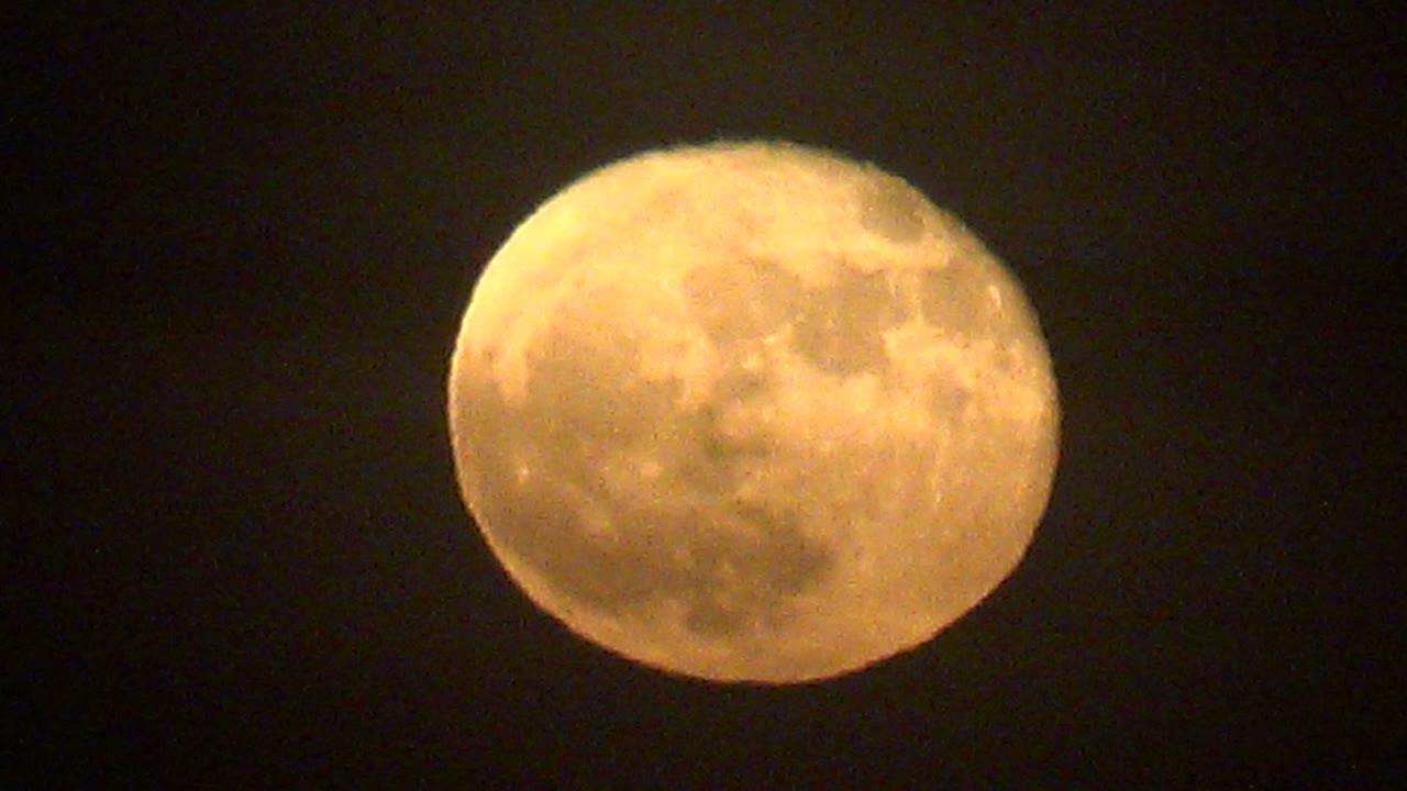 Glowing full moon against an empty dark sky in La Bocana, Baja California Sur, Mexico, with its bright upper edge and no visible people.