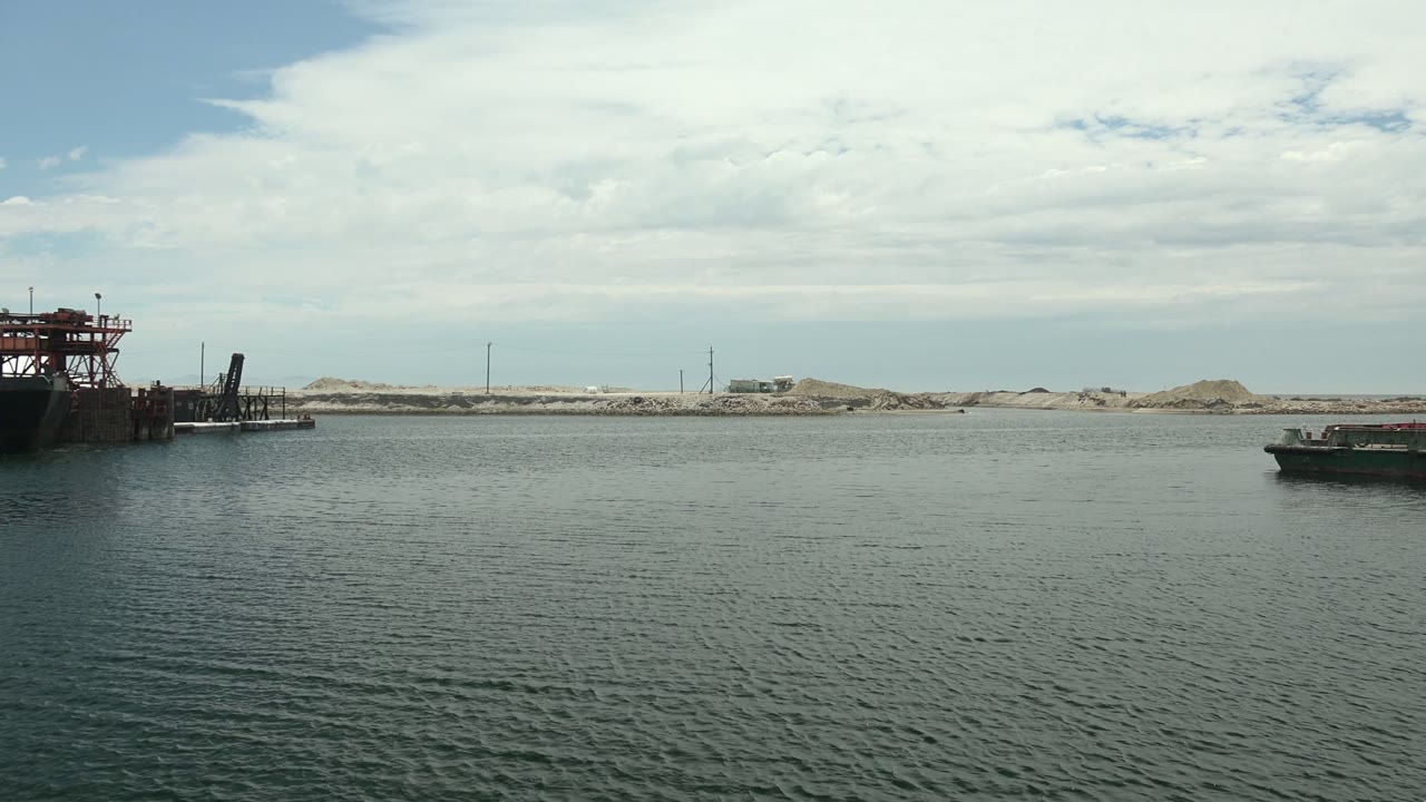 Industrial dock and vessel across calm harbor water